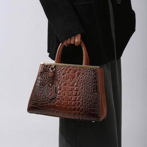Brown crocodile embossed tote bag with gold metal trim and elegant top handle