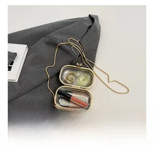 Detail view of the golden capsule evening bag interior with chain and small essentials
