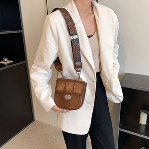 Detail of vintage brown leather crossbody bag with ethnic pattern wide strap