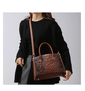 Detail of dark brown crocodile pattern leather tote with triangle logo and shoulder strap