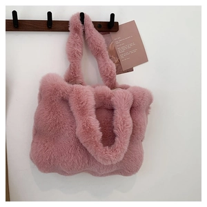 Detail of soft pink faux fur tote bag hanging on a wooden hook with a clean white wall