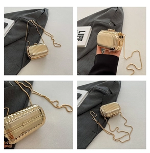 Detailed views of gold mini suitcase clutch with vertical grooves and metal chain strap