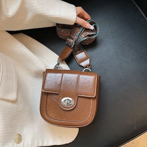 Detail of vintage brown leather crossbody bag with ethnic embroidered wide strap