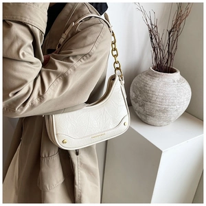 Sac croissant beige minimaliste avec chaîne dorée et cuir texturé au style vintage chic