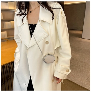 Detail of champagne silver hexagonal metal bag with slim chain strap on white coat