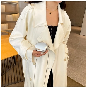 Detail of silver hexagonal mirror metal clutch bag with slim chain on a white coat