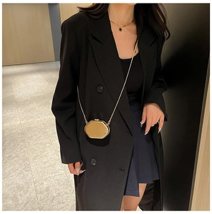 Chic golden octagonal mini evening bag with sleek chain strap styled on model