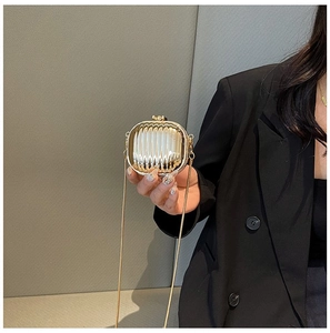 Detailed view of mini gold metallic evening bag with vertical pleated texture and chain