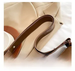 Détail de la large poignée en cuir marron avec surpiqûres sur un sac de ville chic