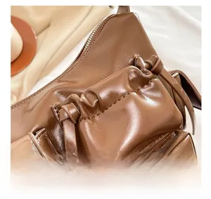 Détail de la texture en similicuir marron avec poche zippée et lanière nouée déco