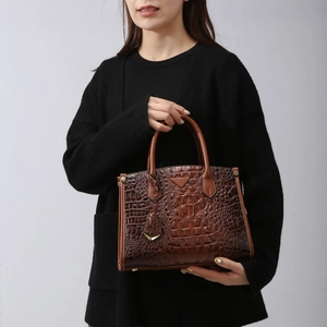 Deep brown crocodile embossed leather tote bag with top handle and metal triangle detail