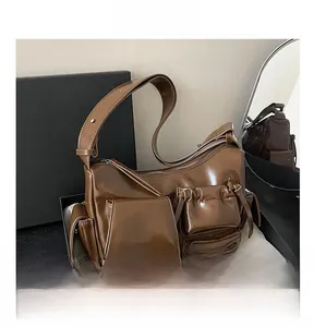 Détail du sac moto en cuir verni marron avec poches extérieures et large bandoulière