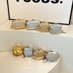 Detailed view of mini metallic evening bags in gold and silver with elegant chain straps