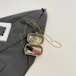 Transparent acrylic evening clutch with gold chain showing storage for lipstick and perfume
