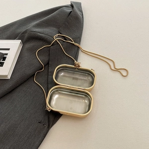 Interior view of a golden capsule evening bag with metal hinge and delicate snake chain