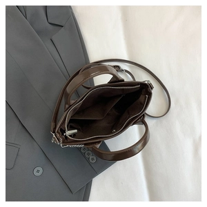 Sac à main en simili cuir marron avec poignées et bandoulière réglable sur blazer de bureau