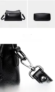 Detail view of black lychee leather bag with metal hardware and zipper back pocket