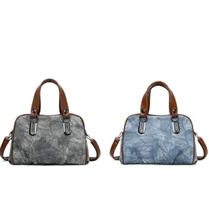 Detail of vintage denim pattern handbags in black and blue with brown handles