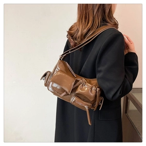 Vue détaillée d'un sac bandoulière marron style biker à poches multiples et œillets