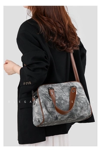 Retro denim crossbody bag with brown leather straps shown on shoulder of a model