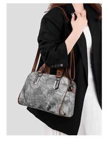 Detail of vintage denim crossbody bag with brown faux leather straps and silver buckles