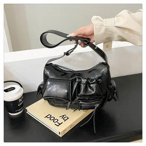 Détail du sac cargo noir brillant à poches multiples avec bandoulière large et zips