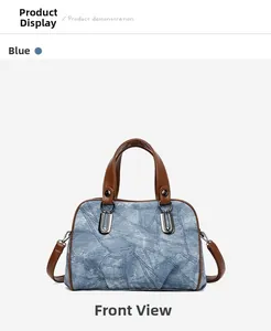 Front view of a blue denim texture handbag with U-shaped metal ring and brown handle