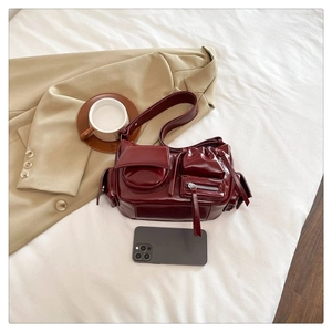 Détails du sac bandoulière en cuir verni bordeaux avec plusieurs poches pratiques