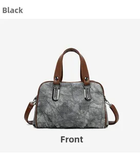 Detailed front view of vintage denim Boston bag with brown faux leather trim and metallic U-rings