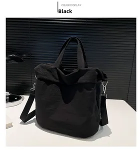 Detailaufnahme der schwarzen Segeltuchtasche mit Faltenstruktur und Metallschnallen
