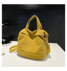 Detail einer leuchtend gelben Nylon-Tragetasche mit verstellbarem Schultergurt
