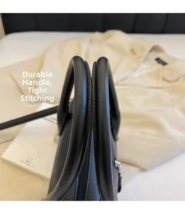 Close-up of black lychee grain leather handbag featuring dual handles and fine stitching