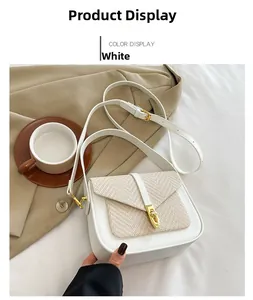 Detail of white textured woven flap and gold twist-lock on vegan leather crossbody bag