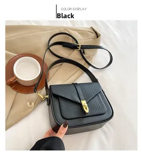 Detail of black faux leather crossbody bag showing gold metal lock and woven texture