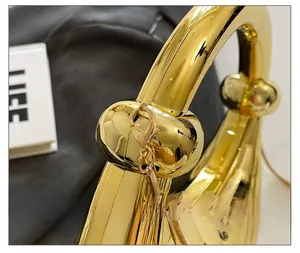 Détail du fermoir et de la poignée en métal doré poli sur un sac à main matelassé rétro