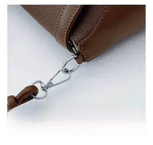 Detail of brown leather and canvas stitching with silver metal hook hardware