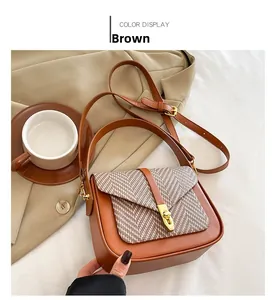 Detail view of brown leather crossbody bag with herringbone fabric flap and gold clasp
