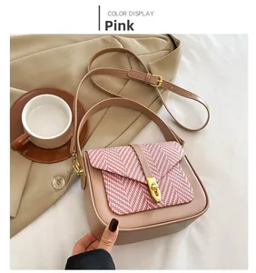 Close-up of pink leather crossbody bag featuring red and white knit textured flap detail
