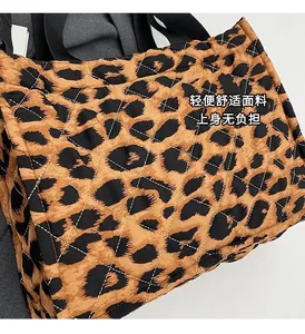 Detail shot of quilted leopard print fabric and black nylon strap on this tote bag