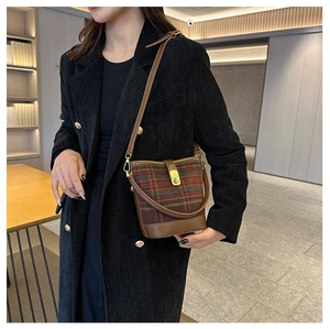 Sac seau vintage à carreaux avec base en cuir marron et fermoir doré sur modèle