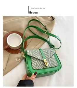 Detailed view of a green crossbody bag with textured wool flap and gold rotating lock