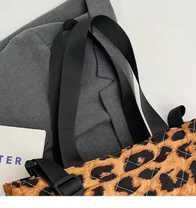 Detail of leopard print quilted tote with adjustable wide black woven shoulder strap