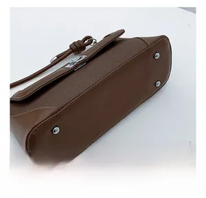 Detail shot of the handbag base with silver protective metal studs and leather seams