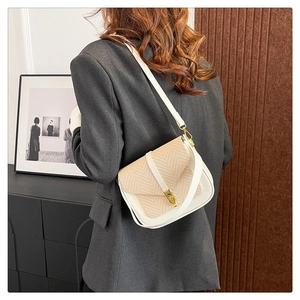 Detail of a cream woven crossbody bag with gold metal buckle and contrast stitching