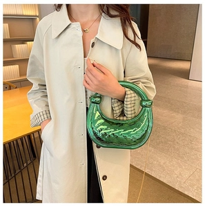 Détail du sac à main tressé vert avec poignée ronde et finition métallique brillante
