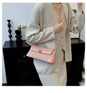 Close-up of pink leather crossbody bag with silver buckle and fine stitch details