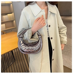 Détail du sac croissant métallisé matelassé avec poignée ronde et chaîne dorée