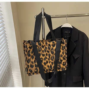 Close-up of quilted leopard print tote bag with adjustable strap on a garment rack