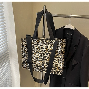 Close-up of leopard print quilted tote bag with black wide straps and soft texture