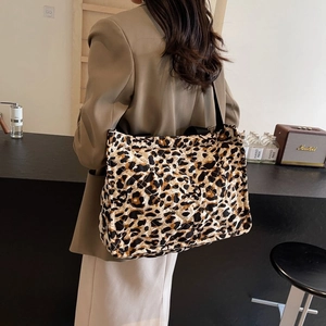 Detailed view of large leopard print quilted tote bag with wide black shoulder strap